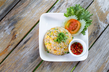 Fried Rice with egg in the white dish on wooden table