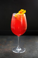 Colourful lemonade, red drink, cocktail on a black stony background.