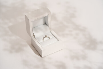 Romantic present for her. Elegant diamond ring in white gift box on white background
