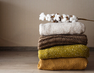 Fototapeta na wymiar a sprig of cotton lies on top of a stack of neatly folded woolen things.