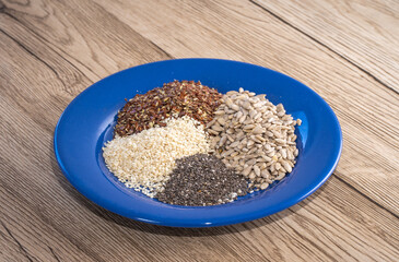 A plate with different seeds - chia, sunflower seeds, sezame and flax or linseed. Health eating.