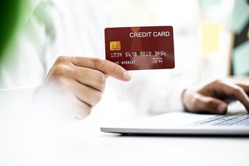 Men hold red credit cards to pay for items purchased through online shopping sites, online shopping is an option that does not leave home, but can shop. Credit card concept.