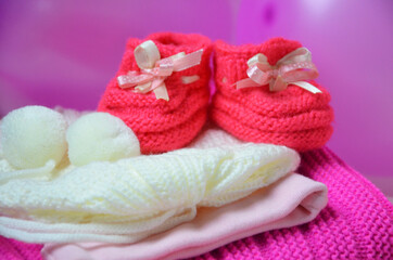 Obraz na płótnie Canvas Baby girl knitted sandal, booties, shoes baby newborn, blank postcard. cocept it s a girl or baby shouer
