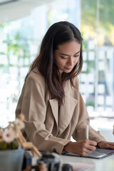 Asian businesswoman working on a tablet at office.