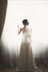 Fototapeta premium Beautiful bride wearing fashion wedding dress with feathers with luxury delight make-up and hairstyle, studio indoor photo shoot