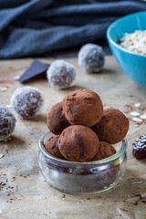 Healthy energy protein balls with dates, oats, peanut butter and dark chocolate. Homemade gluten free truffle bites covered with cocoa powder. Vegan and vegetarian raw appetizer or food snack.