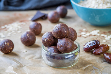 Healthy energy protein balls with dates, oats, peanut butter and dark chocolate. Homemade gluten free truffle bites with no bake. Vegan and vegetarian raw appetizer or food snack. Side view