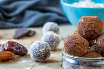 Close up on healthy energy protein balls with dates, oats, peanut butter and dark chocolate. Homemade gluten free truffle bites covered with cocoa powder. Vegan, vegetarian raw appetizer or food snack