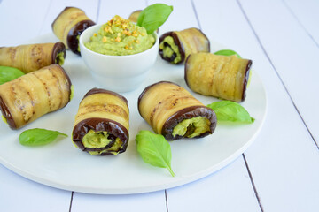 Eggplant rolls. Aubergine rolled with avocado basil sauce and pistachios