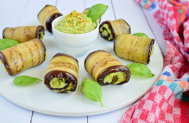 Eggplant rolls. Aubergine rolled with avocado basil sauce and pistachios