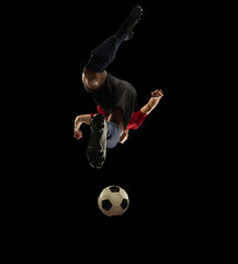 Young caucasian football, soccer player in action, motion isolated on black background, look from...