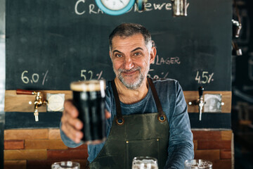 bartender offering a fresh beer in bar