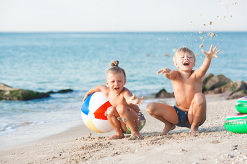 Happy children having fun at the beach. Active kids on summer background.