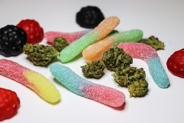 Colorful gummies and green cannabis buds