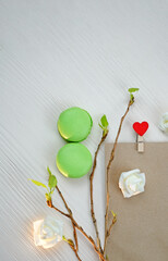 8 March macaroons, envelope, and fresh leaves. Sprig concept, International Womens Day celebrate. Vertical phopto.