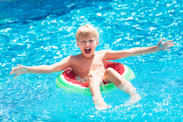 Fototapeta na wymiar Cute little child in swimming pool. Funny kid swimming.