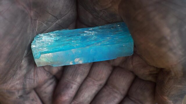 a large crystal lies in dirty male hands.close-up.shallow depth of field
