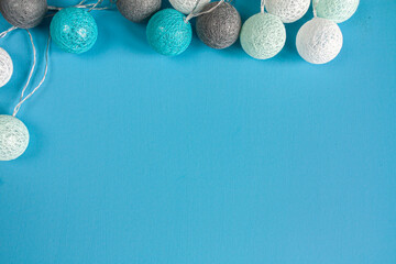 a garland of white, gray and blue balls on blue background