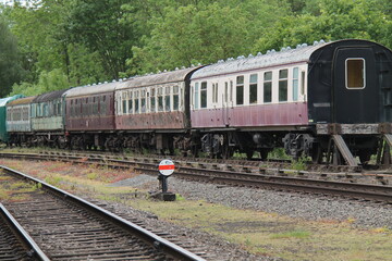 Obraz premium A Row of Vintage Railway Carriages Awaiting Restoration.