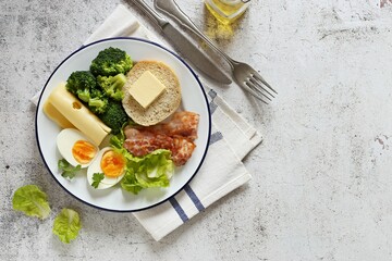 Low carb breakfast with egg, fried bacon, broccoli and gluten free keto bread. Flat layot, copy space