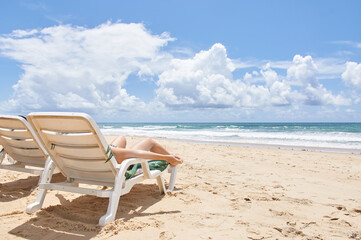Fototapeta na wymiar People on deck chairs relaxing in Praia do Amor Brazil