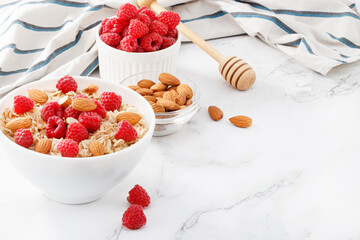 Healthy breakfast. Bowl with oatmeal with fresh raspberries and almonds. Copy space