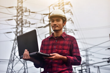 Engineer hold laptop computer inspection on site power plant high volte system