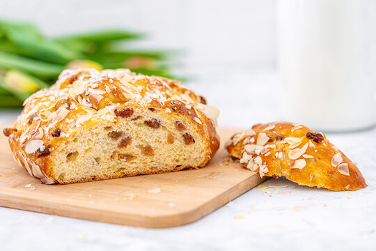 Osterbrot im Anschnitt mit Milch auf Holzbrett