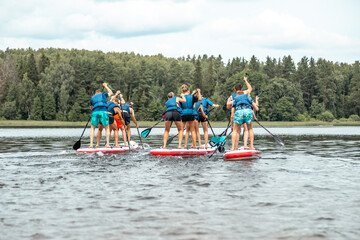 Stand up paddle SUP race competition. People rowing with Dragon boards in SUP festival. awesome...