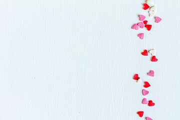 small red, pink and white hearts on white background