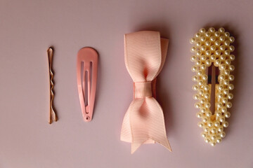 Pink, pearl and gold hair clips on pink background. Topv iew.