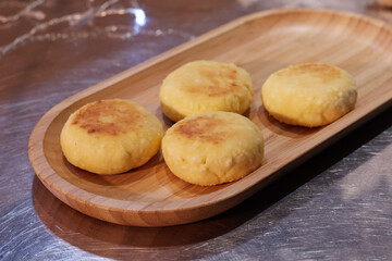 ready fried cheesecakes lie in a plate on a tray on the table the background is blurred