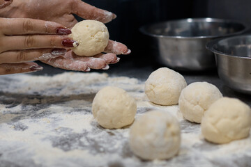 woman chef preparing dough makes the cheesecakes in the kitchen close up blurred background