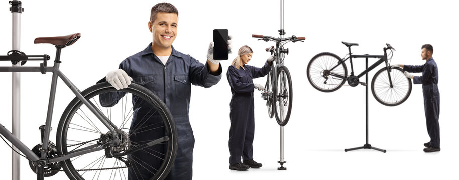 Mechanics repairing bicycles and holding a mobile phone