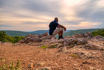 Man enjoying the view at the top of a mountain during a hike of Taum Sauk Mountian, the highest elevation point in Missouri.