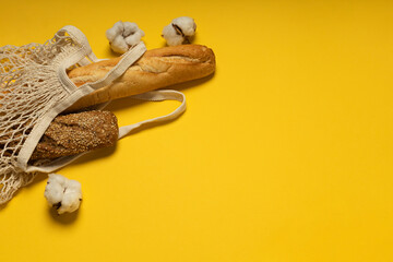 Bread in cotton eco-friendly bag on yellow background
