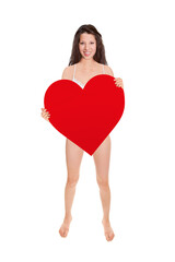 Full length portrait of a beautiful young woman wearing white lingerie and holding a big red heart, studio photo isolated in front of white background