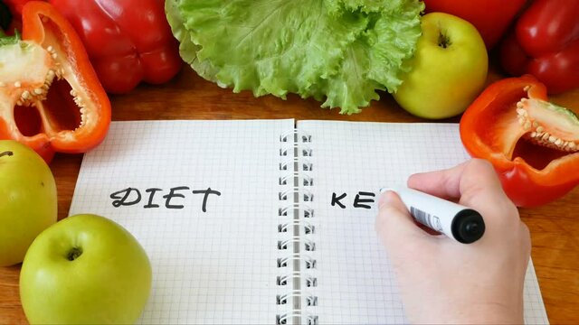 notebook with a diet plan with fresh vegetables and fruits on table, keto diet