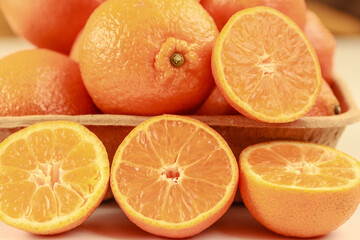 Macro of fresh juicy seedless tangerines, oranges halved on biodegradable pulp paper food tray. Tasty fresh fruit.  Close up, stock photo