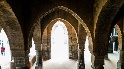Fototapeta na wymiar Malda, West Bengal, India - January 2018: The arches in the arcaded corridors and interiors of the ancient Adina Masjid mosque in the village of Pandua.
