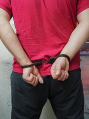 men's hands cuffed behind their backs