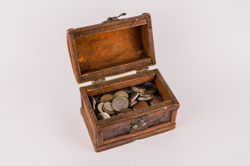 old wooden chest with many different coins