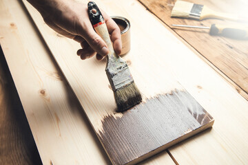 man holding paint brush on wood