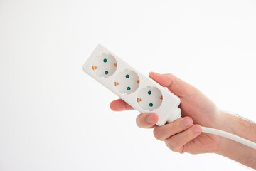 Electrical cord with multiple plug sockets held in hand by Caucasian male hand isolated on white