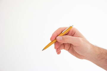 Yellow vintage plastic ball pen held in hand by Caucasian male hand making gesture studio shot isolated on white