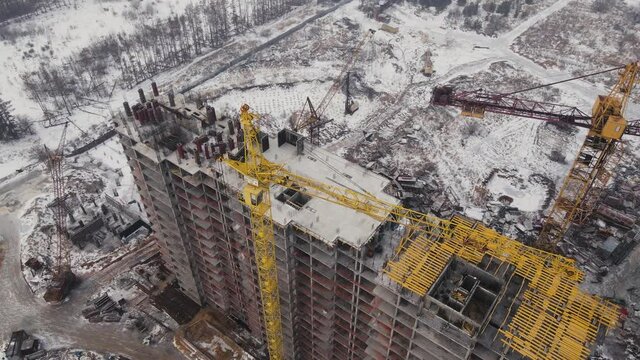 Building under construction in Winter with snow. Residential constructions development site and real estate constraction.