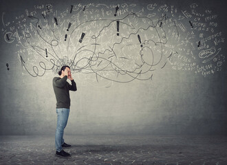 Side view full length of pensive and fatigue man suffers headache, pointing hands to temples. Guy...