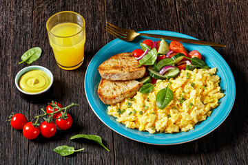 scrambled eggs with veggies and bread on a plate
