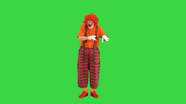 Clown in red outfit playing imaginary piano on a Green Screen, Chroma Key.