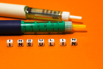 inulin syringe, insulin syringe pen and the inscription insulin from cubes, orange background. 